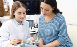 Pacjentka rozmawia z lekarką, która pokazuje jej wyniki